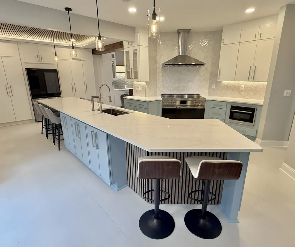 Bright modern kitchen with light blue shaker cabinets and a spacious open layout — wide view.